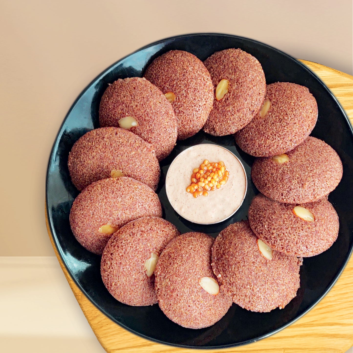 Black plate with ragi idli and white chutney for breakfast