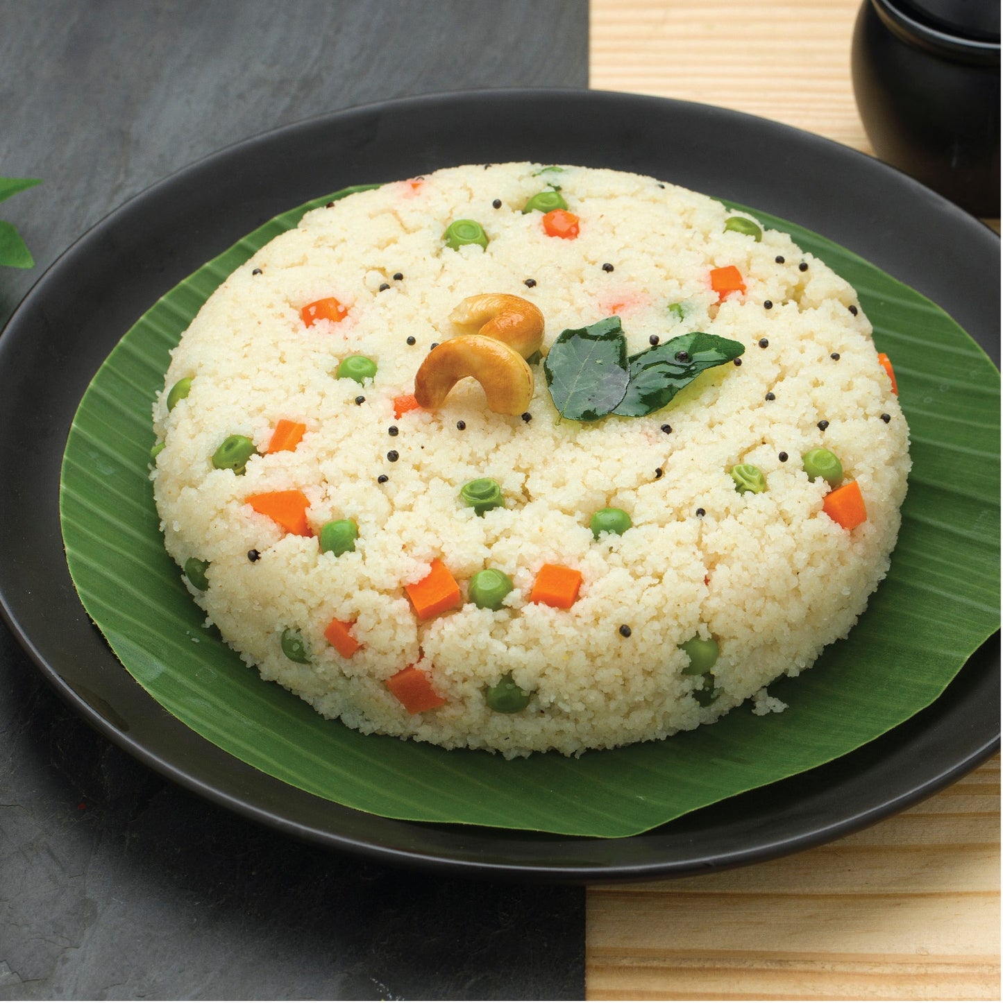 Delicious Multi Millet Upma with veggies, cashews, and green leaf plate