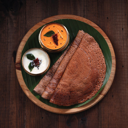 Healthy ragi idli served with coconut chutney on a brown plate