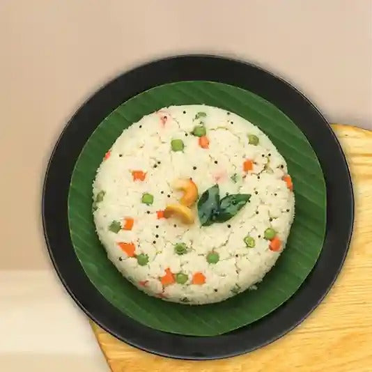Delicious Multi Millet Upma with veggies, cashews, and green leaf plate
